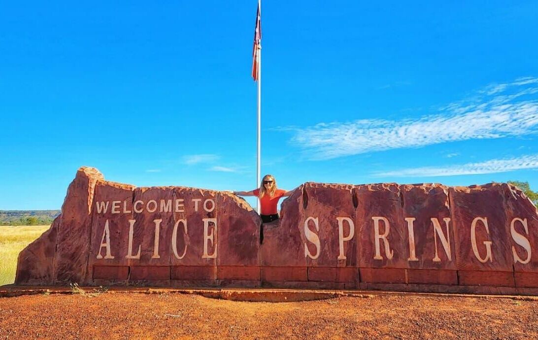 Jean Hailes team member at Alice Springs entrance sign