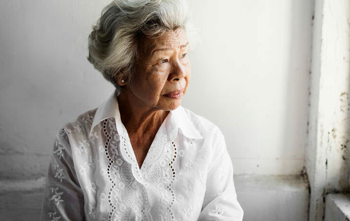 Elderly asian woman thoughtful expression