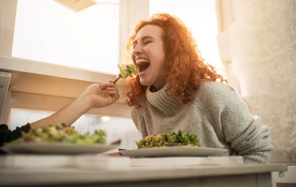 Young woman eating salad 599 400
