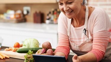 Older woman at kitchen bench with food