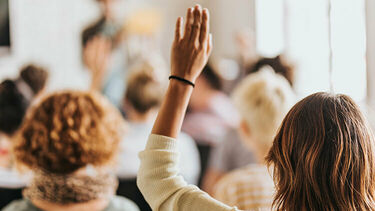 A woman raising her hand in a meeting