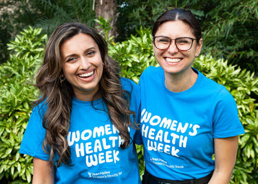 Two smiling women in Women's Health Week t-shirts