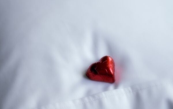Red love heart on white bed sheets 600 399