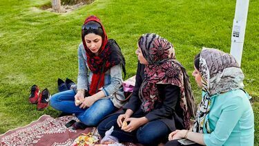 Women in headscarves sitting on lawn