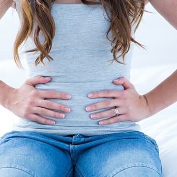 woman with pelvic pain holding her abdomen