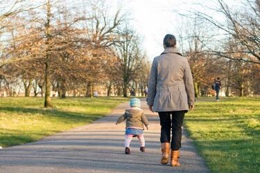 Women and daughter walking in park