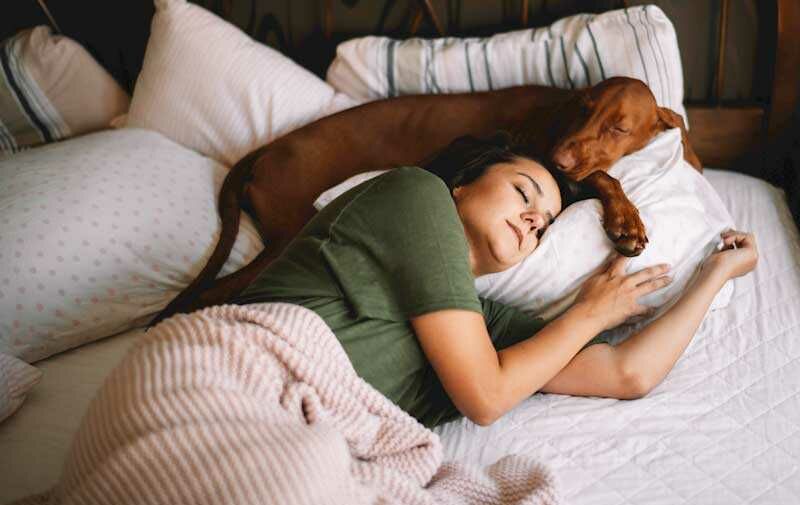 Girl sleeping with her dog on pillow