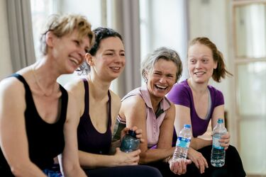 Women group at gym laughing working out resting