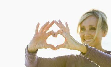 Woman holding heart symbol in hands