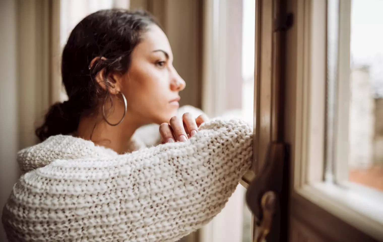 Pensive woman in front of window