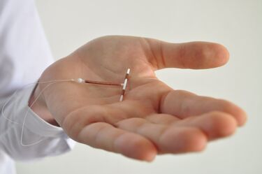 Holding iud birth control device in hand