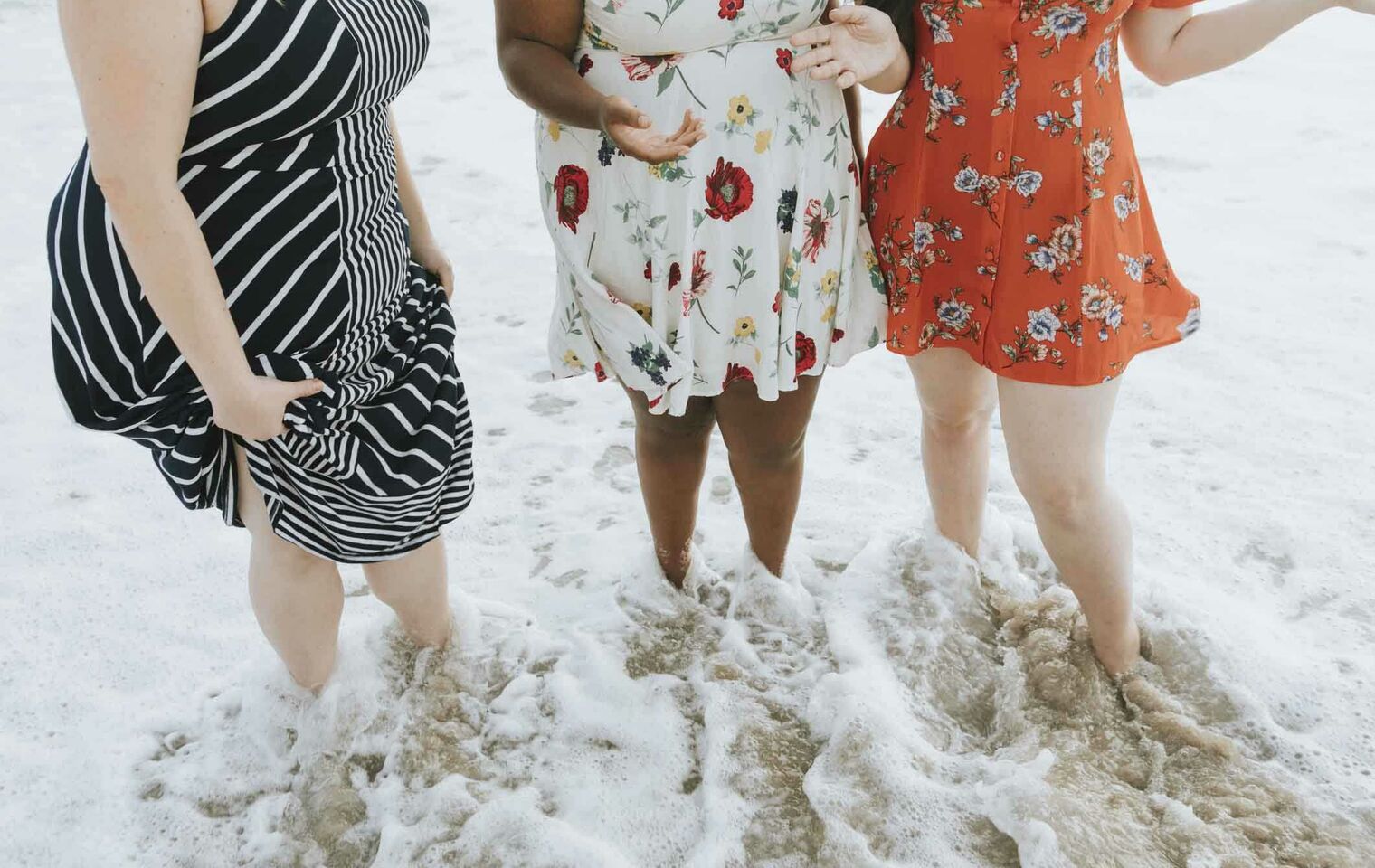 Three women standing at beach