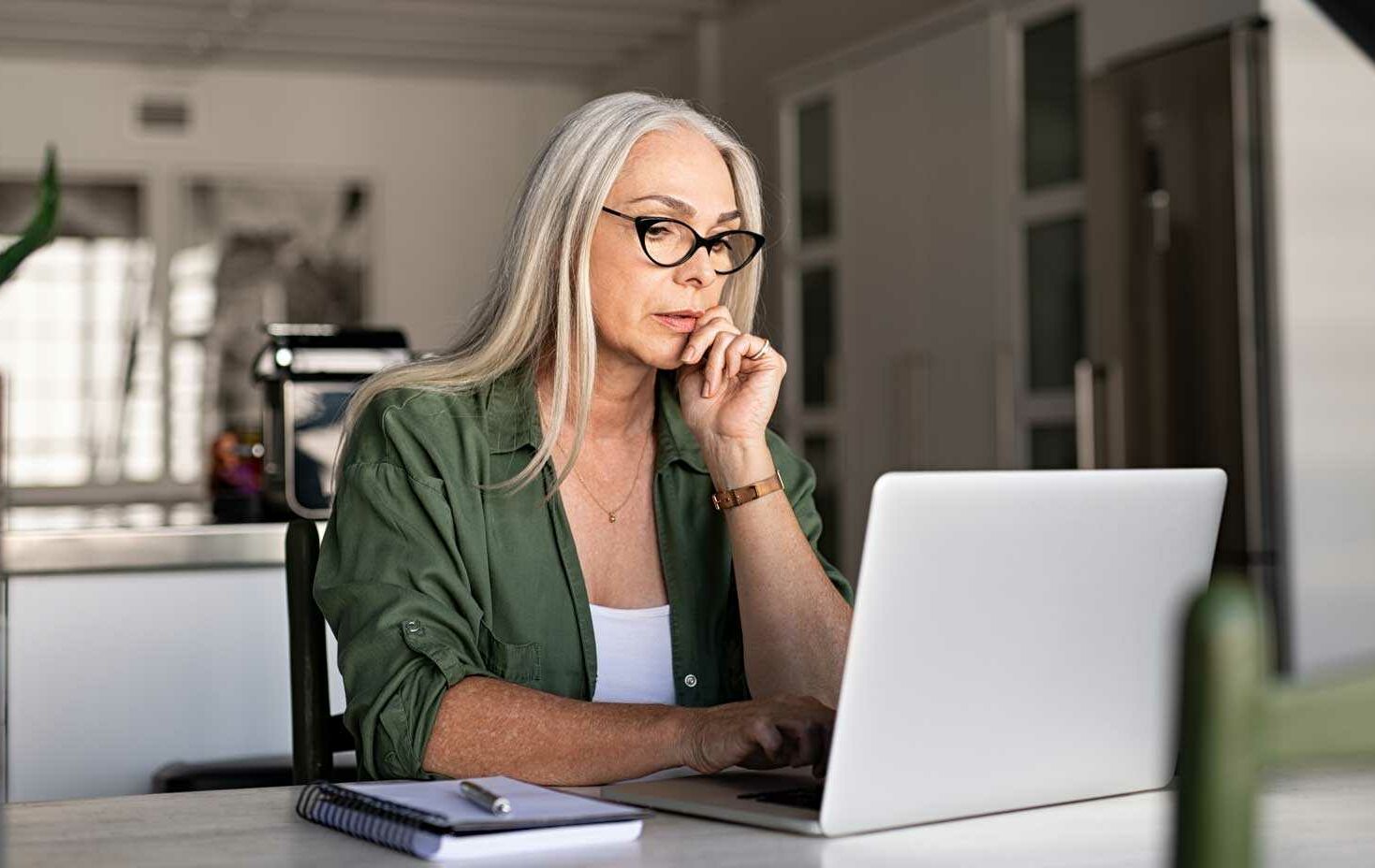 Focused older woman using laptop