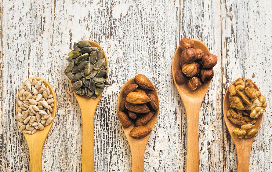 Nuts and seeds on wooden spoons