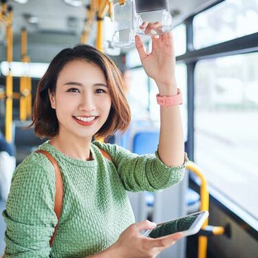 Young chinese woman with smart phone on bus