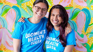 Two women hugging in Women's Health Week t-shirts